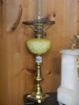 A Victorian candlestick oil lamp with yellow font.