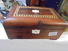 A mahogany inlaid box with padded lining.