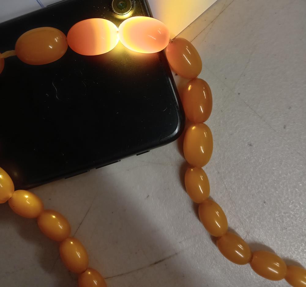 An amber coloured bead necklace. - Image 5 of 6