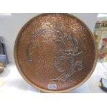 An Arts & Crafts hammered copper wood bound drinks tray, 35 cm diameter.