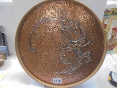 An Arts & Crafts hammered copper wood bound drinks tray, 35 cm diameter.