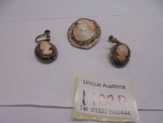 A silver mounted cameo brooch and a pair of cameo earrings.