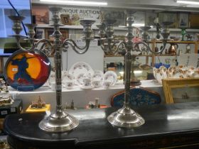 A pair of tall silver plate candelabra.