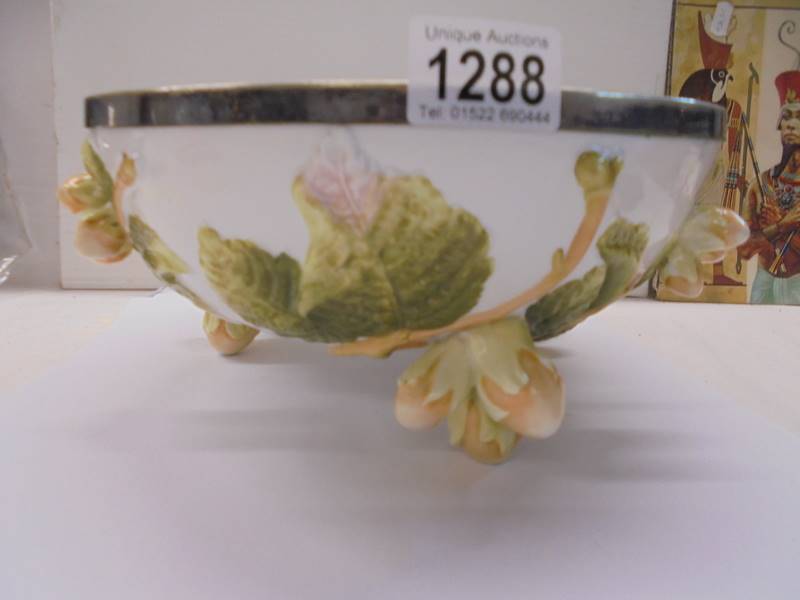 An unusual fruit bowl with acorn feet and plated rim, 26 cm diameter.