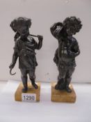 A pair of bronze 'Wheatsheaf' cherubs on bases, 20cm tall.