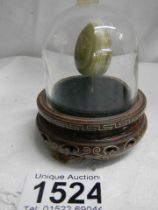 A mid-20th century Chinese onyx egg under glass dome.