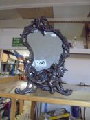 A metal framed art nouveau style mirror featuring cherubs.