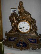 A French mantel clock with hand painted porcelain panels and surmounted figure, in working order.