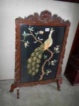 A mahogany fire screen with embroidered peacock panel. COLLECT ONLY.
