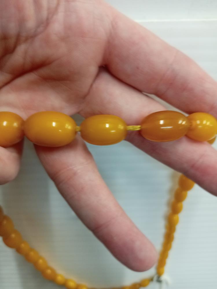 An amber coloured bead necklace. - Image 6 of 6
