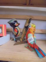 A vintage unbranded tinplate clockwork woodpecker and a dancing bird.