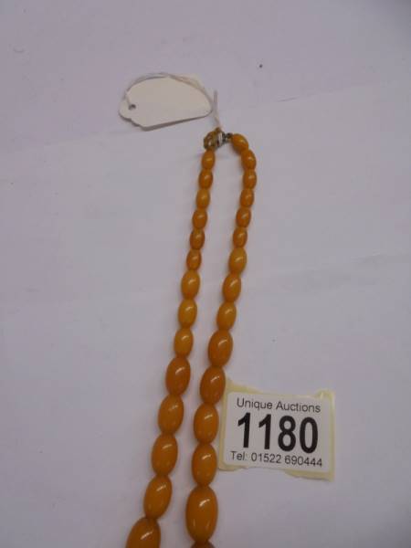 An amber coloured bead necklace. - Image 3 of 6