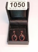 A pair of 9ct gold earrings set red stones.