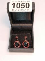 A pair of 9ct gold earrings set red stones.
