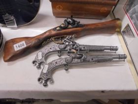 A replica blunderbus pistol and a pair of replica pistols (for display only).
