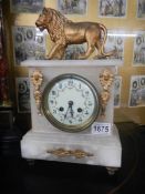 An alabaster mantel clock with lion on top. in working order.