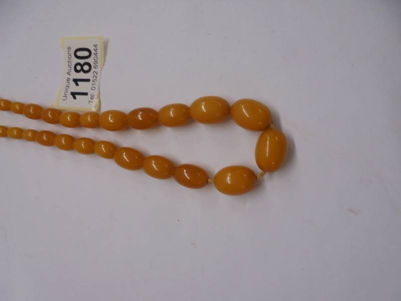 An amber coloured bead necklace. - Image 2 of 6