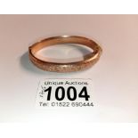 A 9ct gold engraved bangle, 10.7 grams.