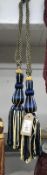 A pair of blue and gold curtain tie backs with tassel