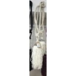 A pair of white curtain tie backs with gem / bead effect embellishment and tassels