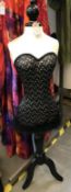 Mannequin with black bodice, sequins and feather trim