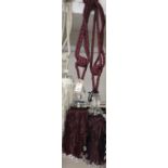 A pair of red wine curtain tie backs with ribbon and gem effect embellishment and tassels
