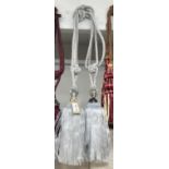 A pair of sliver curtain tie backs with large gem effect embellishment and tassels