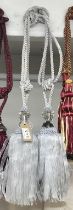 A pair of sliver curtain tie backs with large gem effect embellishment and tassels