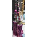 A pair of hanging tassels in purples and pinks with gem / beads embellishment