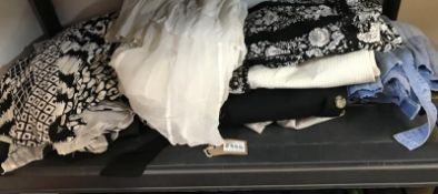 Two shelves of clothing in various colours sizes and styles