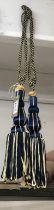 A pair of royal blue and gold curtain tie backs with tassels