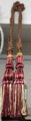 A pair of red wine & gold curtain tie backs with tassels