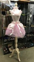 A mannequin with pink netting and embellishments