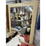 A large mirror with a light wood frame