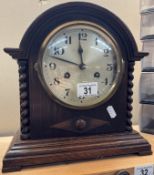 A 1930s oak mantle clock with barley twist pillars, pendulum present but has no key. Last serviced