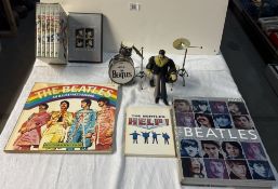 A quantity of The Beatles related figures, Drum set, books, DVDs etc
