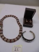 A silver bangle set with white stones, a vintage necklace and a pair of silver stone set earrings.