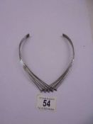 A silver choker/necklace.