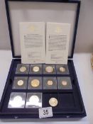 Eight cased Queen Elizabeth II coins and a Victoria coin.
