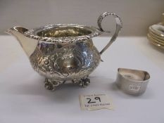 A silver milk jug and a silver napkin ring.