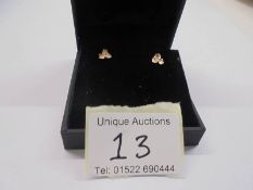 A pair of 9ct gold ear studs fashioned as flower heads.