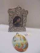 An un-marked silver framed religious print and a metal oval miniature religious plaque.