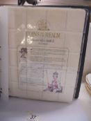 A coins of the realm folder with a Queen Elizabeth II cover, a D Day cover and a replica newspaper.