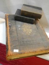 A large old Bible and two smaller examples.