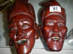 A pair of wooden Asian wall masks.