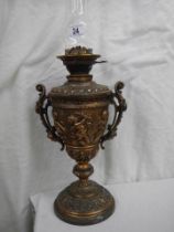 An old spelter oil lamp featuring cherubs and with a drop in font.