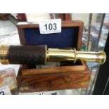 A brass telescope in a wooden box.