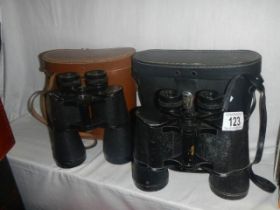 Two cased pairs of binoculars.