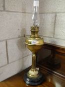 A brass oil lamp on a pot base.