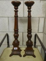 A pair of tall wooden candlesticks.